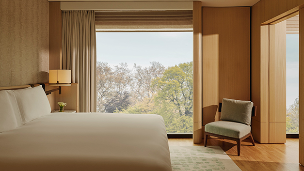 The Emory Corner Park Suite bedroom. A double bed sits to the left in front of a large window with views on to Hyde Park, London